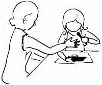 Ребенок ест самостоятельно, угол стола отделяет его от мамы